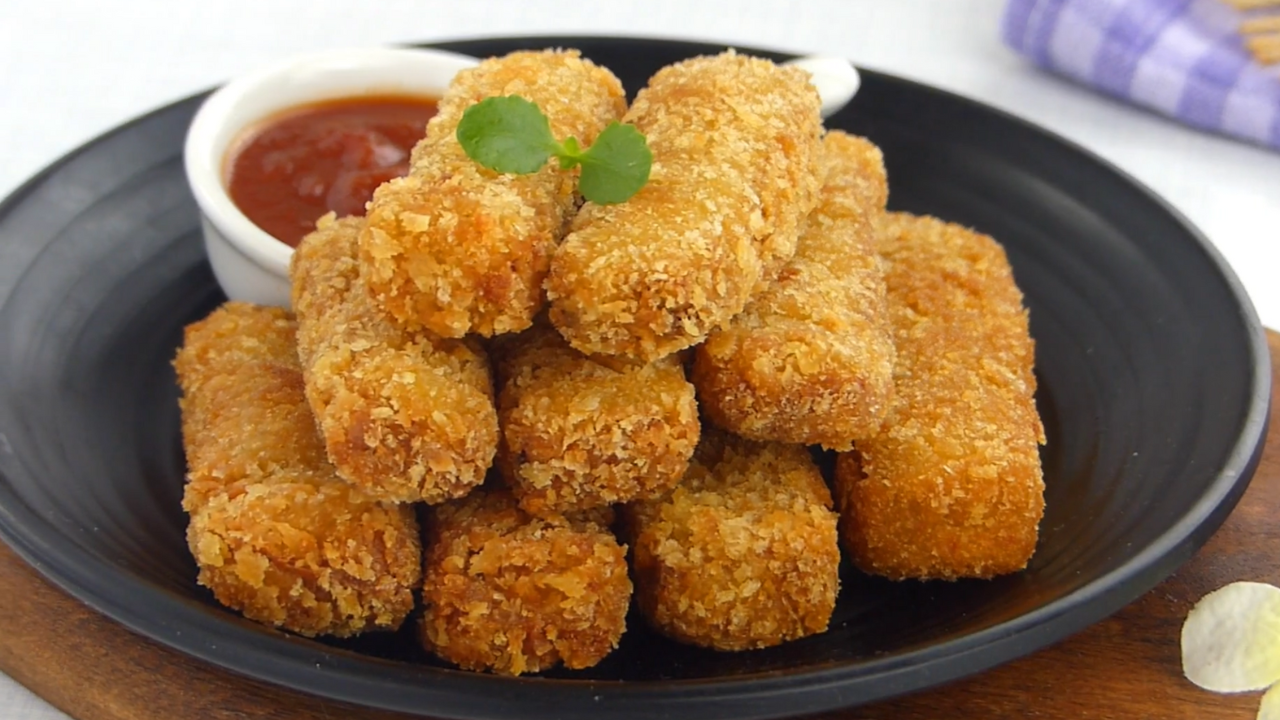 Crispy eggplant fingers arranged on a plate with a dipping sauce on the side