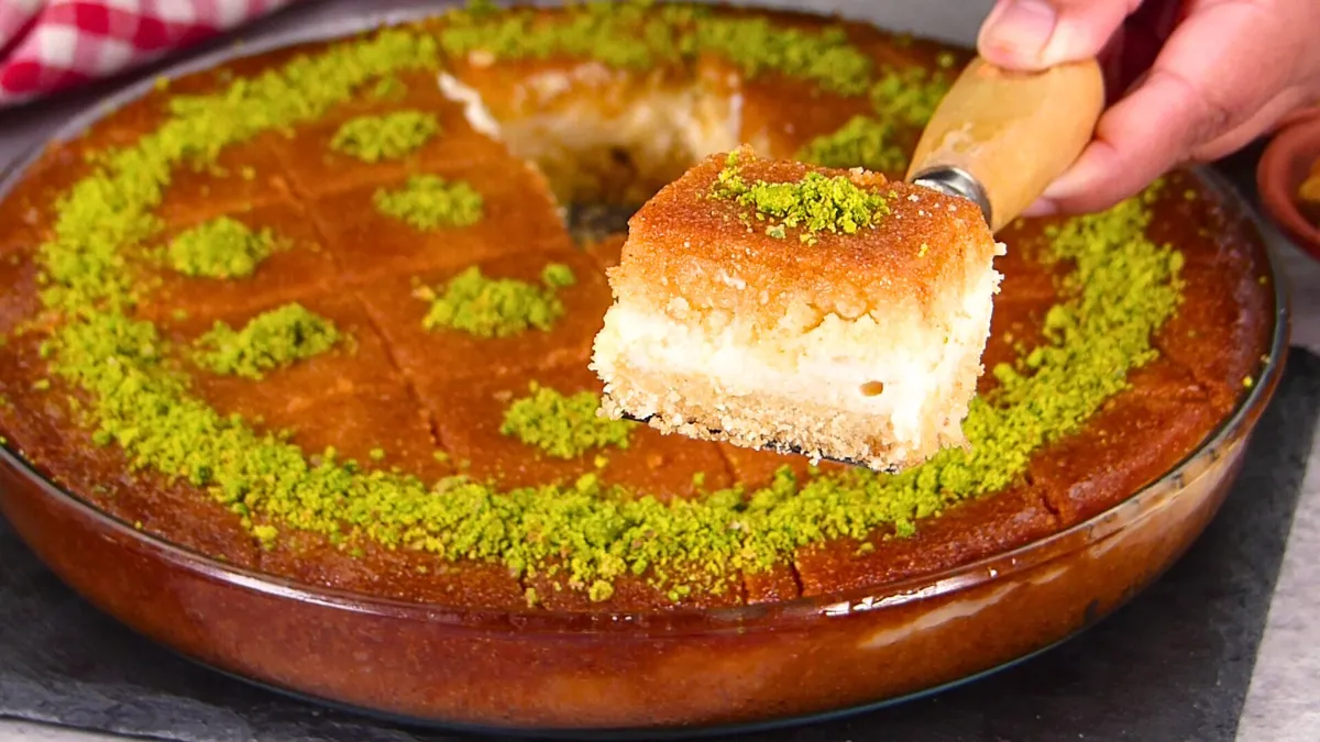 Slices of basbousa cake with a cream layer, topped with syrup